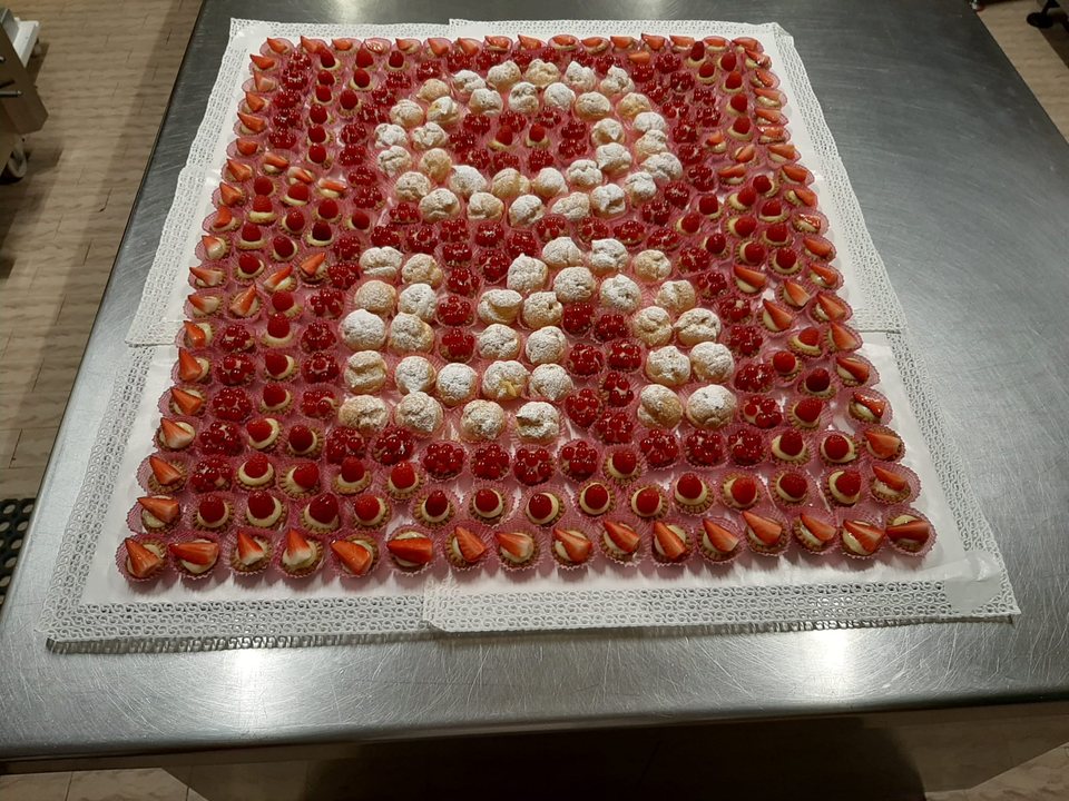 Composizione di pasticcini mignon alla frutta e bignè per una ricorrenza